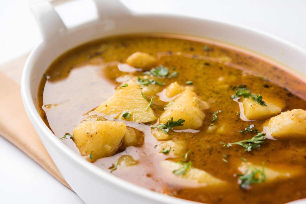 A bowl of hearty potato soup garnished with fresh herbs