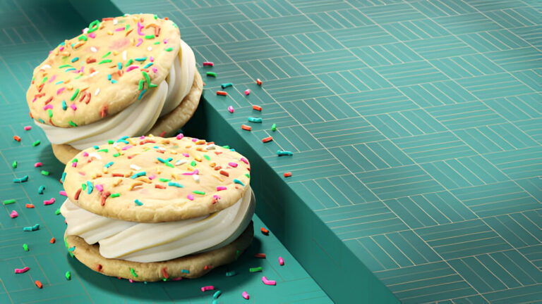 Two large cookie sandwich desserts with colorful sprinkles on a turquoise surface.