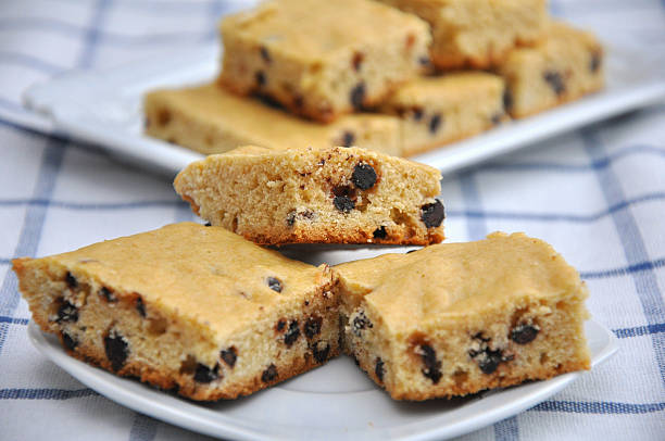 Delicious chocolate chip cookie bars on a plate, with some stacked in the background.