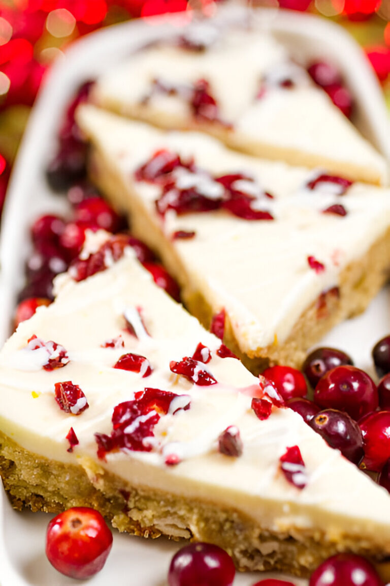 Sliced cranberry cheesecake on a plate with fresh cranberries and a festive background