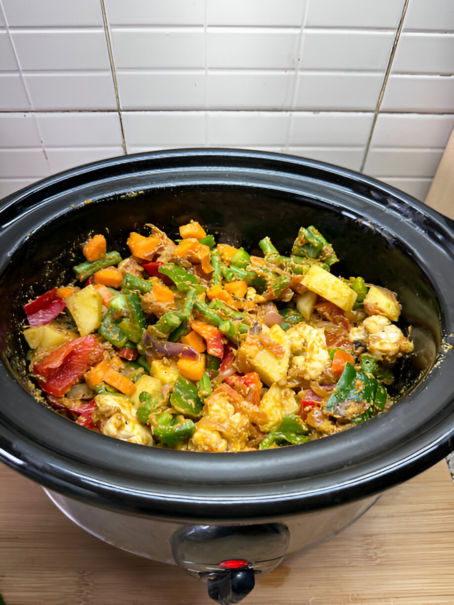 A delicious mix of colorful vegetables cooking in a crockpot.
