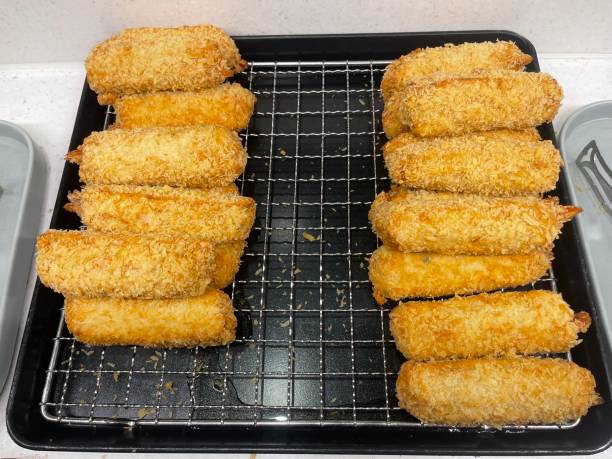 A tray of freshly cooked croquettes on a cooling rack.