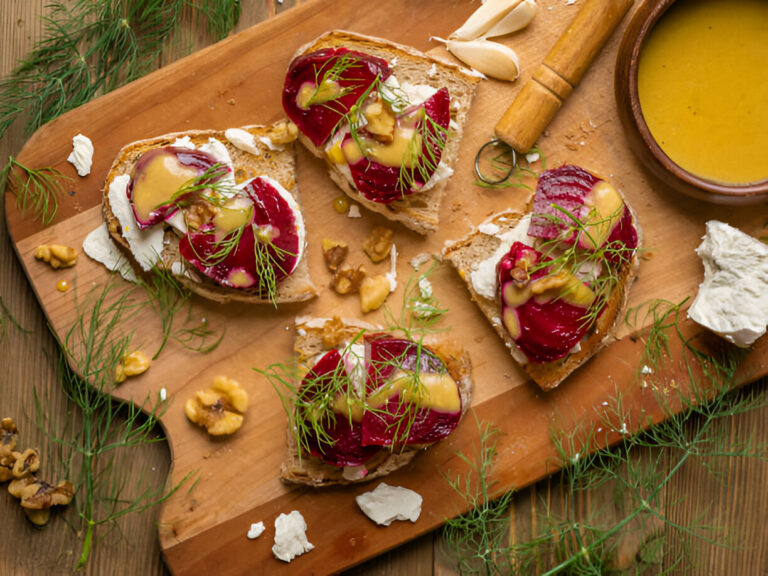 Delicious beetroot and cream cheese toast with walnuts on a wooden board.