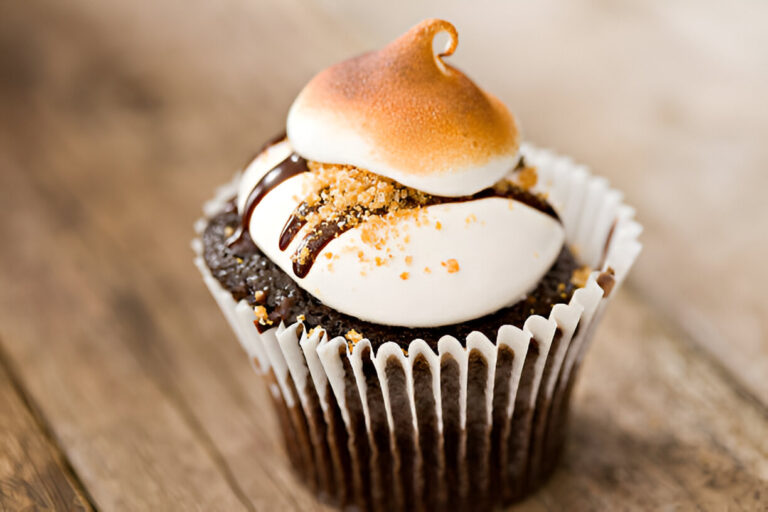 Delicious chocolate cupcake topped with toasted meringue and drizzled with chocolate sauce.
