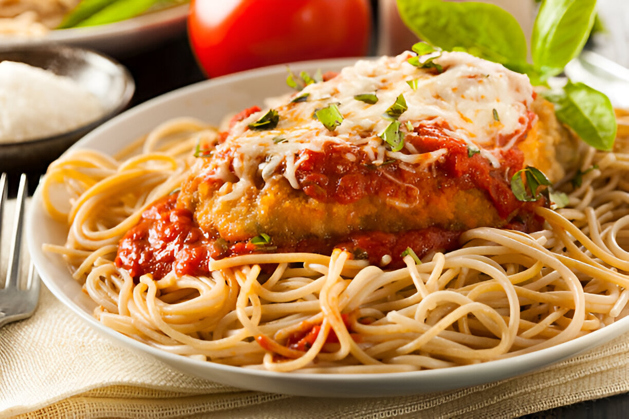 Plate of spaghetti topped with breaded chicken, marinara sauce, and cheese